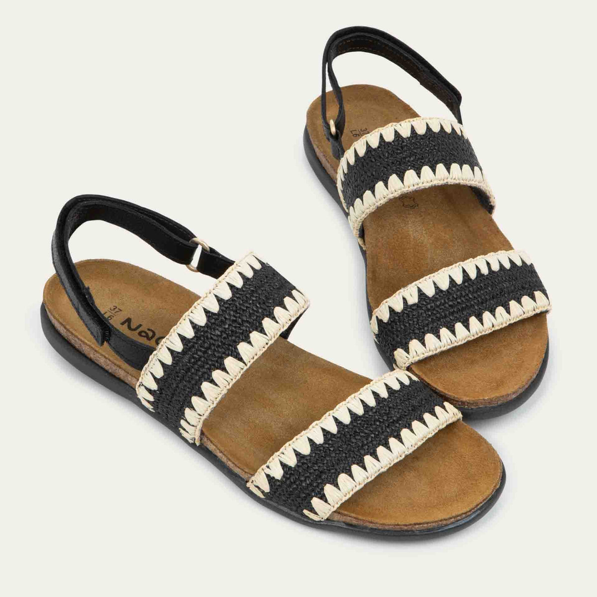 Pair of black sandals featuring two textured toe straps and an adjustable ankle strap on a cork footbed.