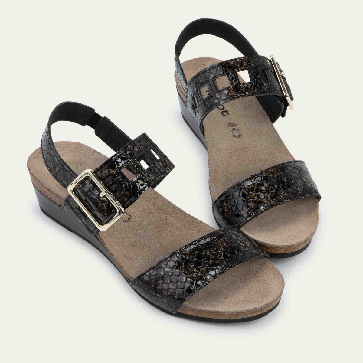 Pair of black wedge sandals with a snakeskin design, featuring two straps and a metallic buckle with a cork footbed.