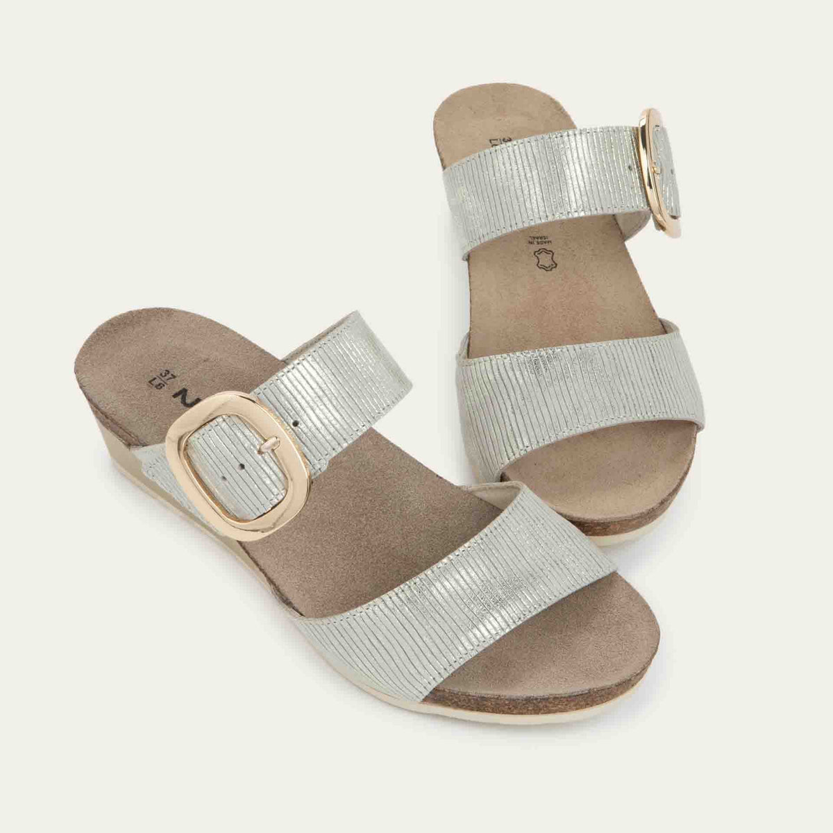 Pair of metallic gray textured wedge sandals with two straps and a large gold buckle.