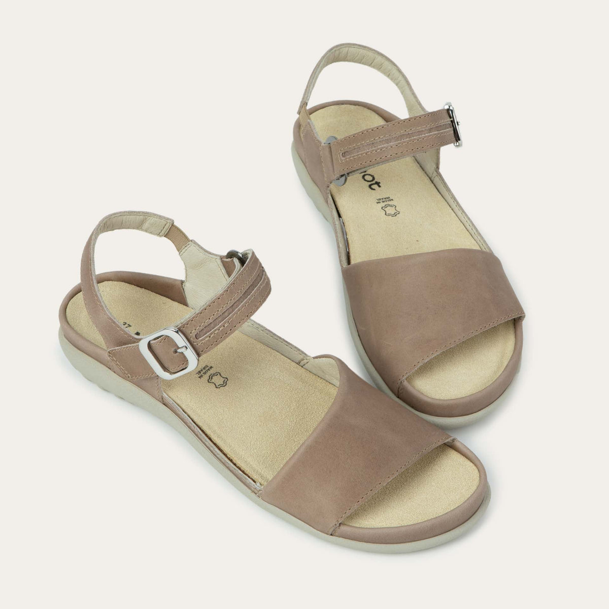 Pair of beige, open toe sandals, featuring a toe strap and asjustable ankle strap with a silver accent buckle.