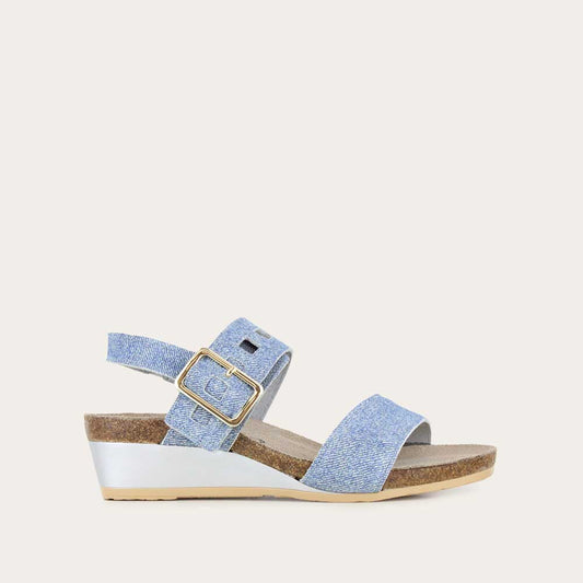 Profile view of a blue denim wedge sandal, featuring two straps and a metallic buckle with a cork footbed.