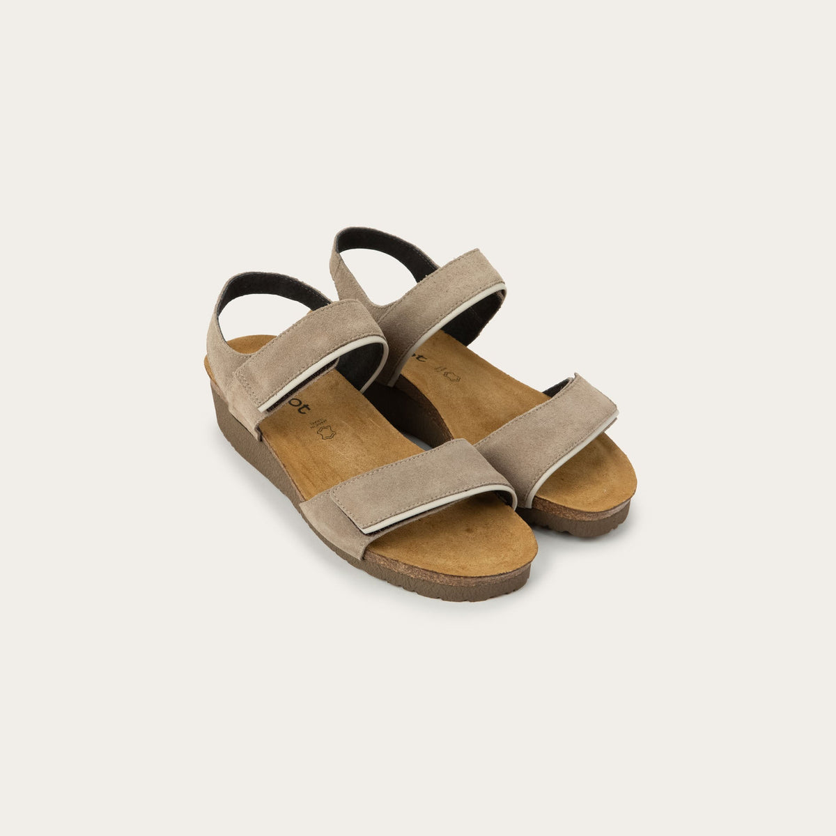 A pair of beige suede sandal with a cork platform sole.