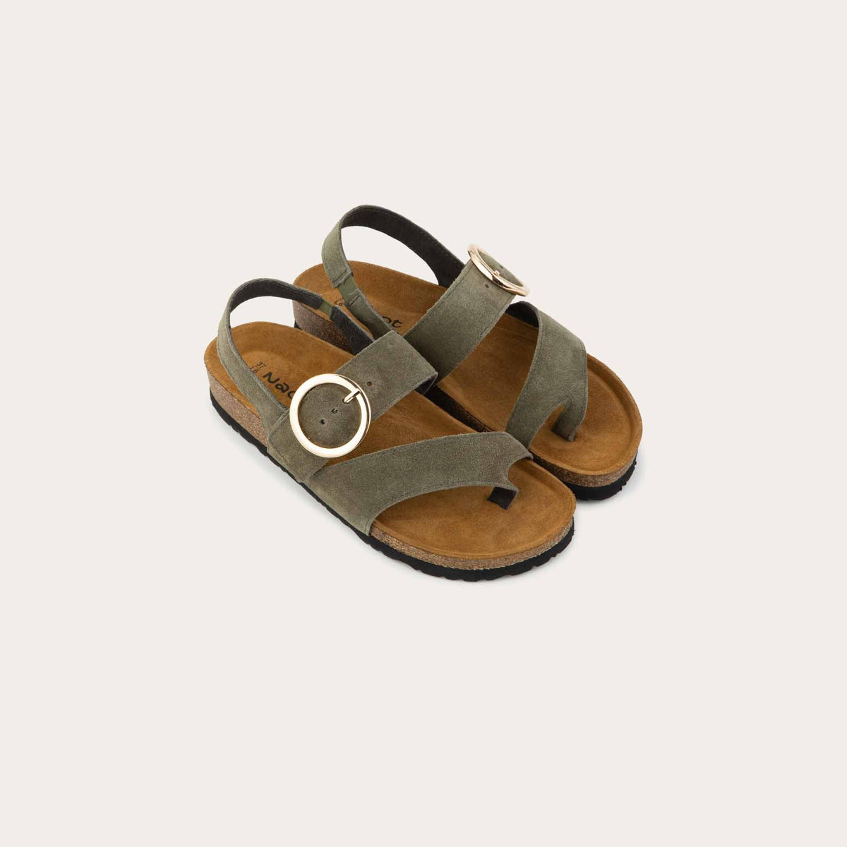 Pair of green strappy slides with an oversized buckle and a toe thong, featuring a cork sole.
