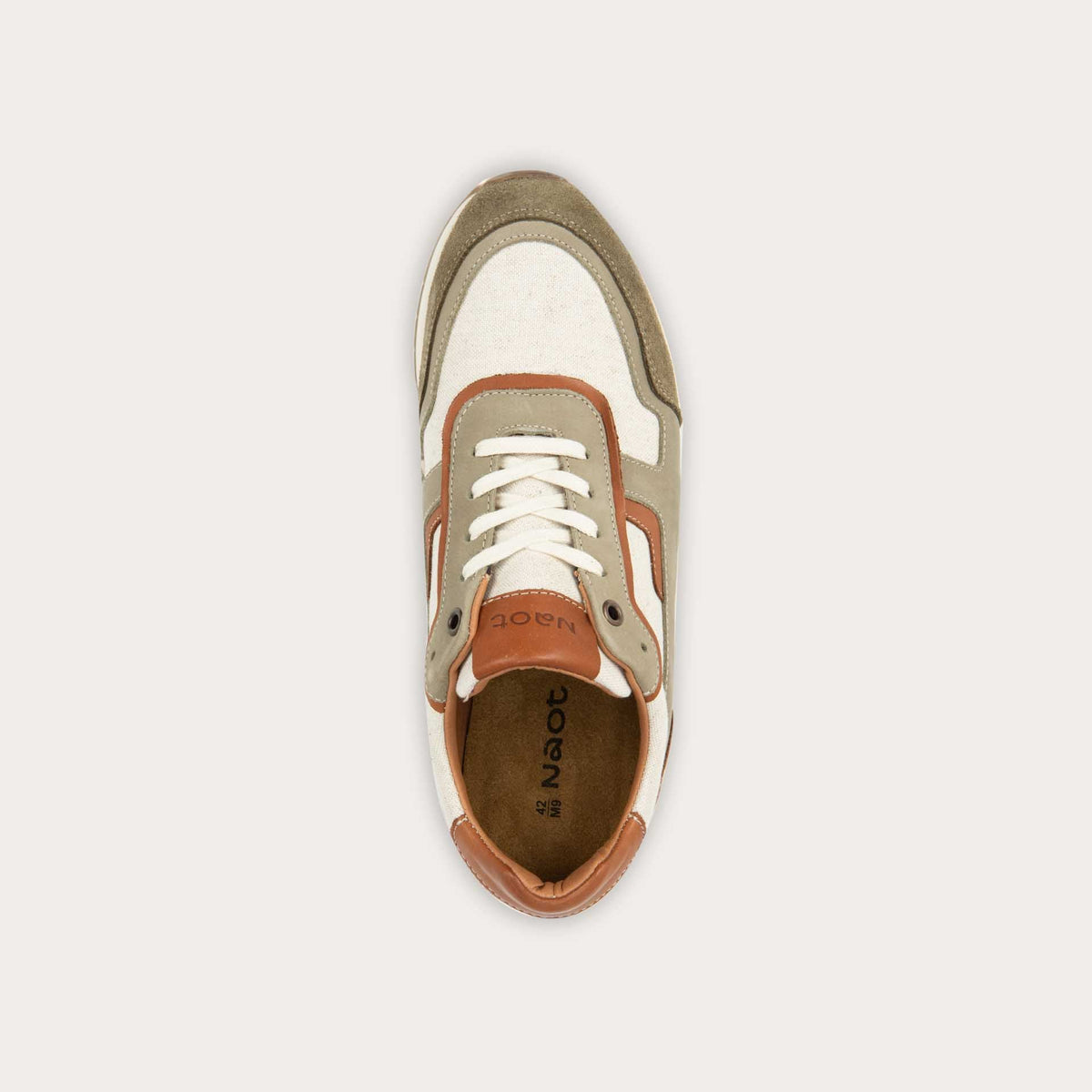 Top view of a green and beige sneaker featuring different materials on a white sole