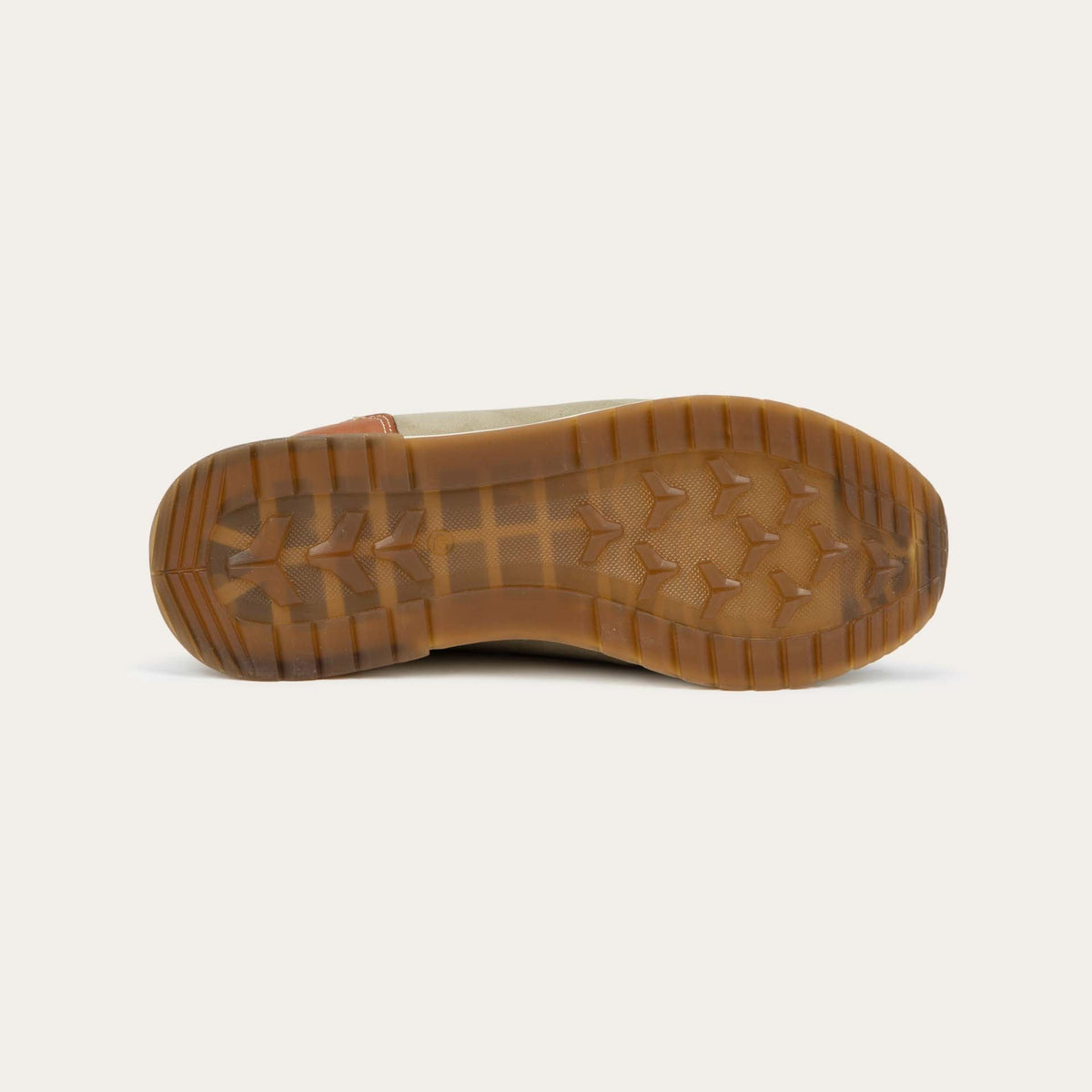 Bottom view of a green and beige sneaker featuring different materials on a white sole