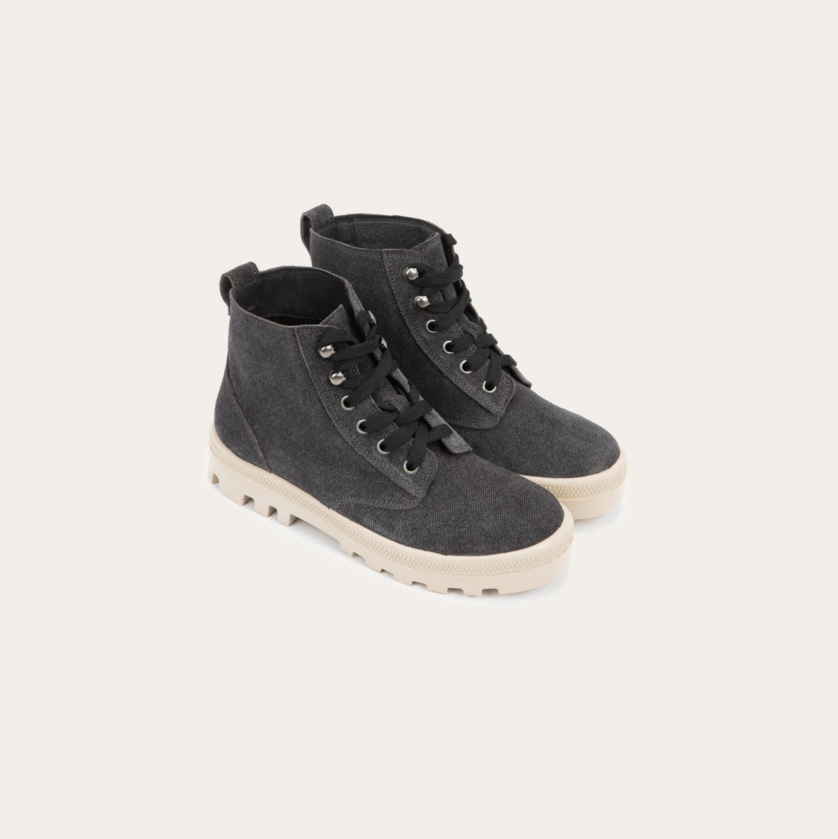 Pair of  black textured suede high-top boots with black laces and a light beige sole. 