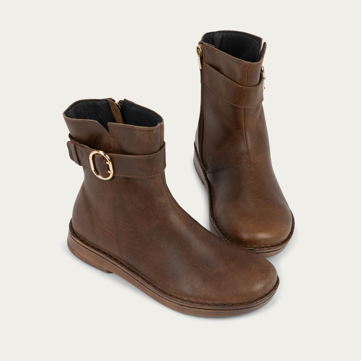 Pair of  brown calf boots with a simple strap and buckle detail