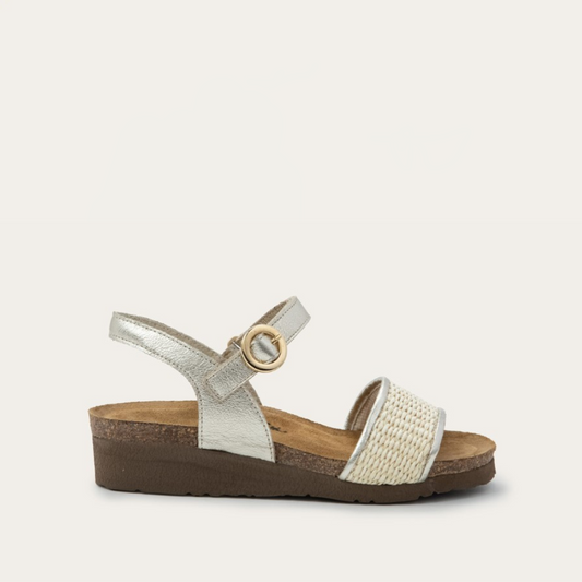 A beige and brown sandal with a faux buckle hook and loop strap, and raffia detailing on the front strap, on a white background.