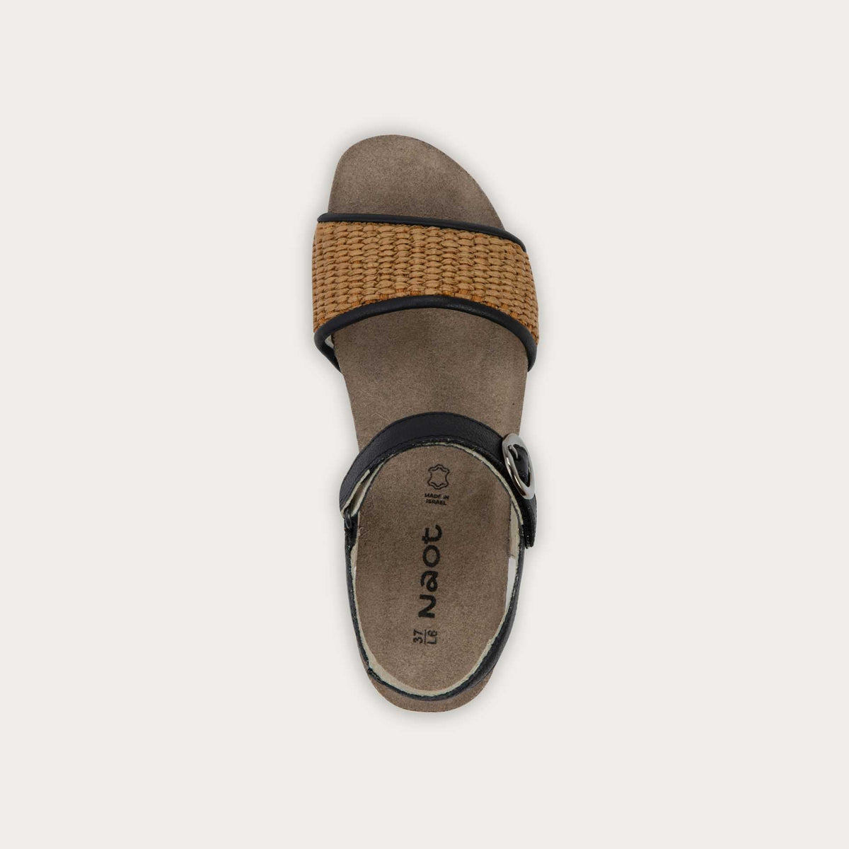 Top view of a sandal with a black ankle strap and buckle, cork wedge sole, and a woven tan strap on the front. 