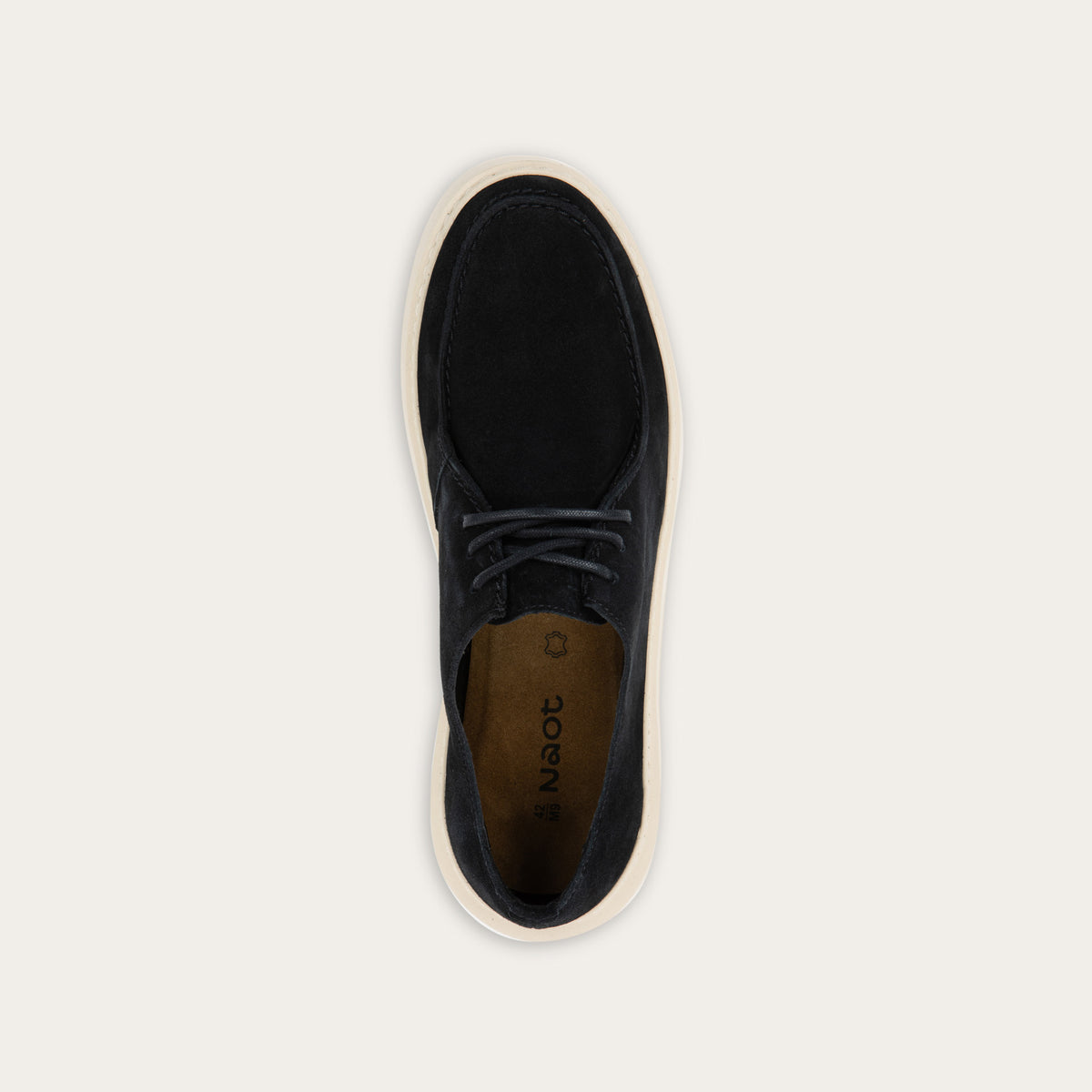 Top view of a black suede lace-up shoe with a moccasin-style toe and a thick, cream-colored rubber sole.