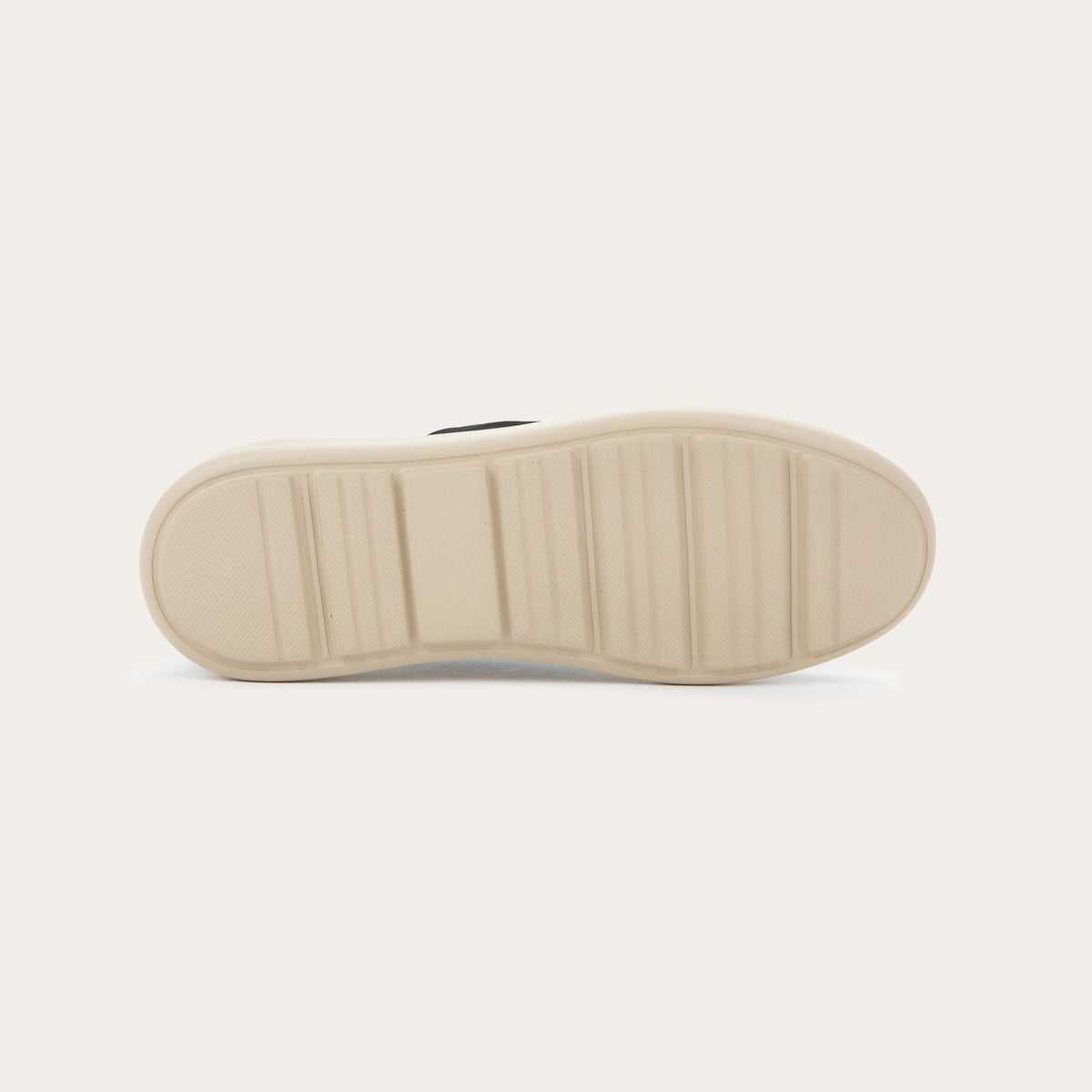 Bottom view of a black suede lace-up shoe with a moccasin-style toe and a thick, cream-colored rubber sole.