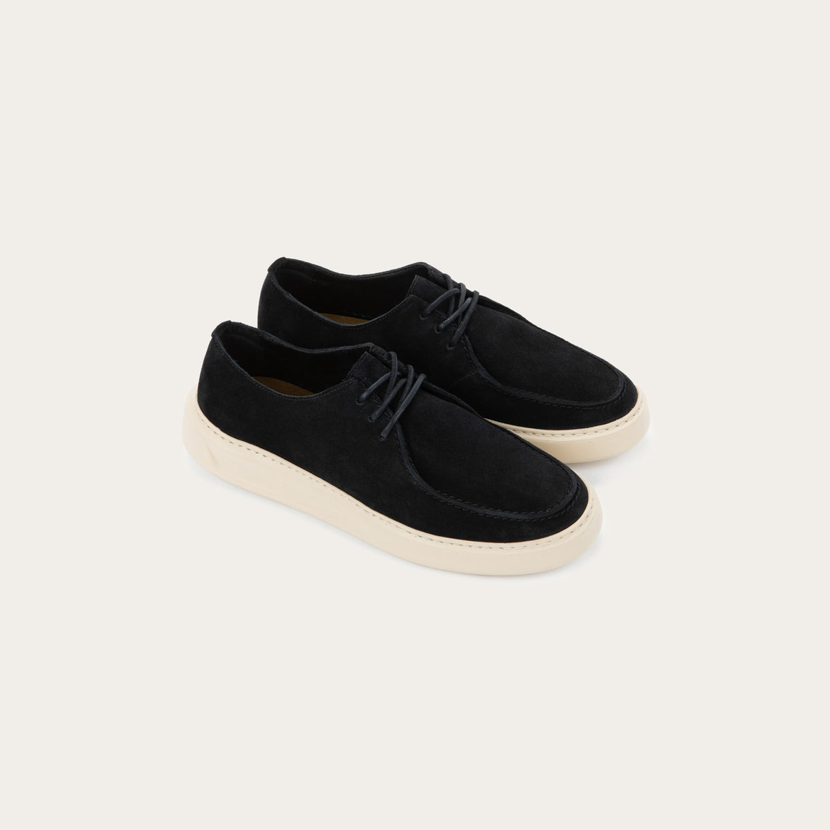 Pair of black suede lace-up shoe with a moccasin-style toe and a thick, cream-colored rubber sole.