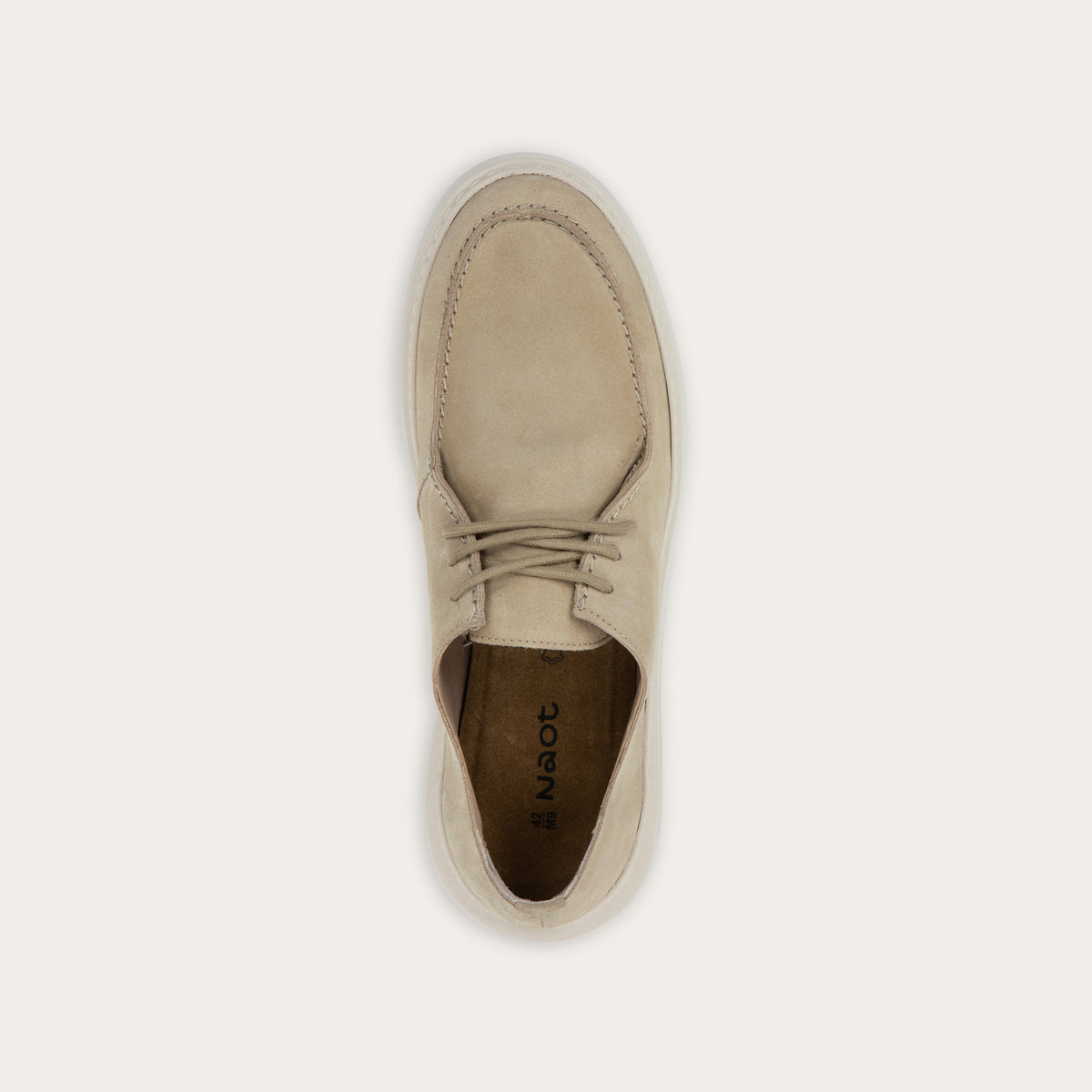 Top view of a beige suede lace-up sneaker with a thick, matching rubber sole and a  stitched toe.