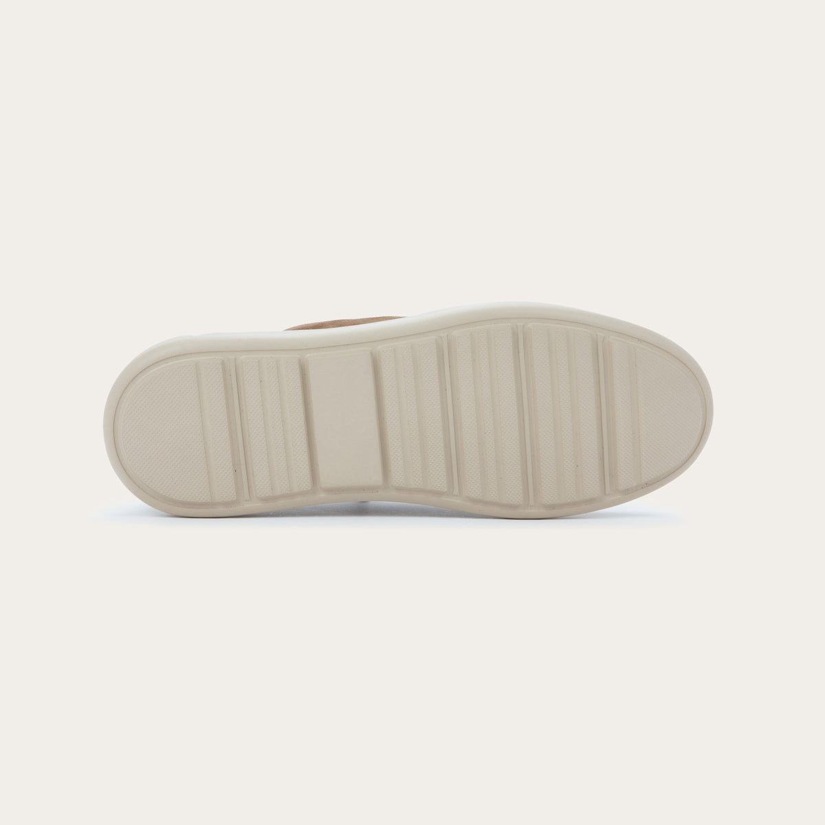 Bottom view of a brown suede lace-up shoe with a thick, off-white rubber sole, featuring a stitched toe and a clean, minimalist design.