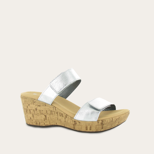 Silver wedge sandal with cork sole on a light gray background