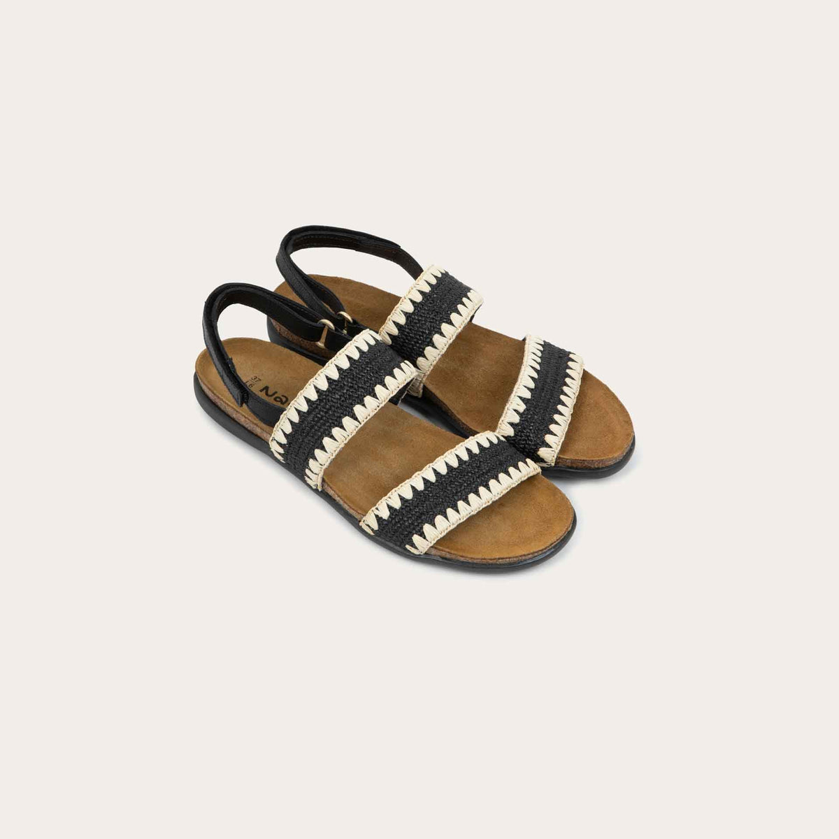 Pair of  black sandals featuring two textured toe straps and an adjustable ankle strap on a cork footbed.