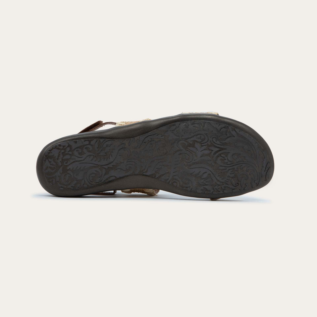 Bottom view of a brown sandal featuring two textured toe straps and an adjustable ankle strap on a cork footbed.