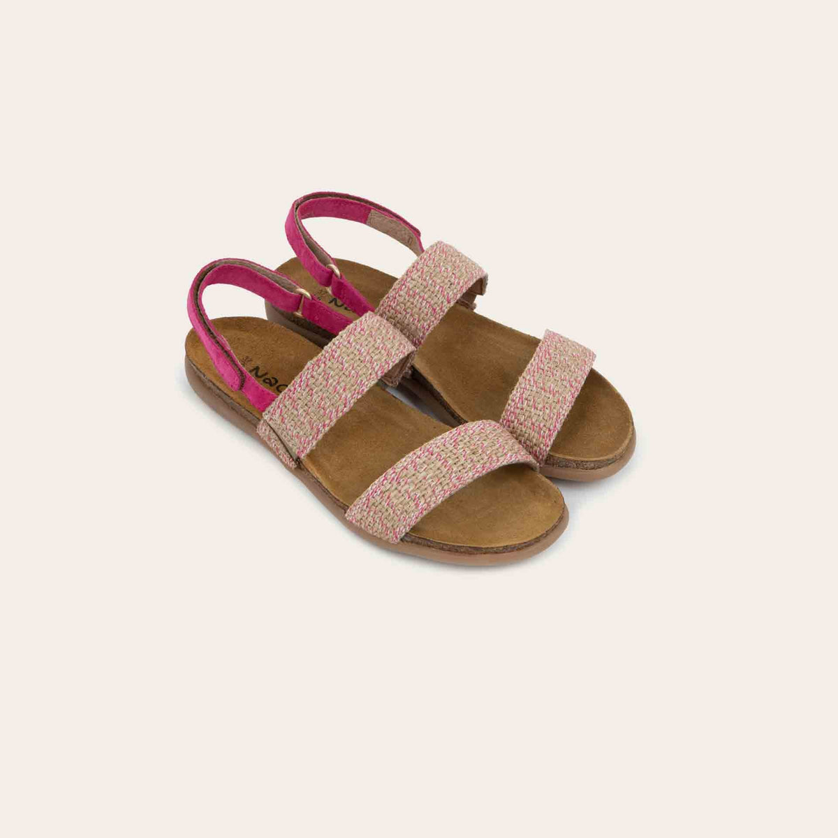 Pair of  pink sandals featuring two textured toe straps and an adjustable ankle strap on a cork footbed.