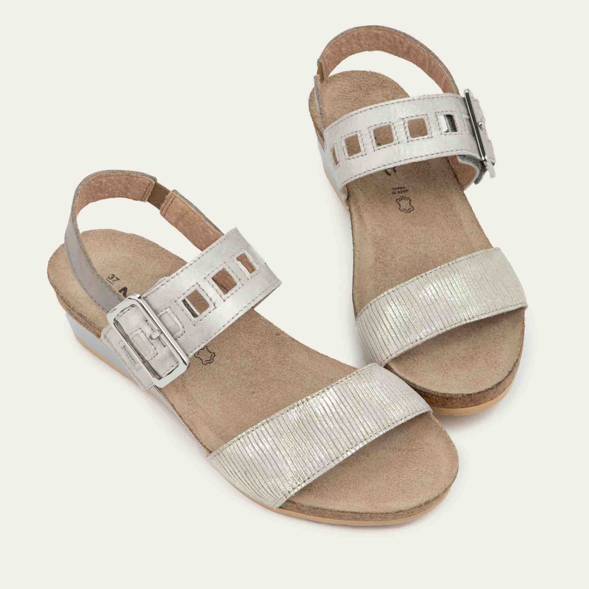Pair of  grey/beige metalic wedge sandals, featuring two straps and a metallic buckle with a cork footbed