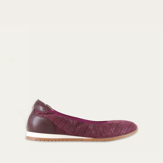 Profile view of a textured purple suede flat on a low white and beige sole. 