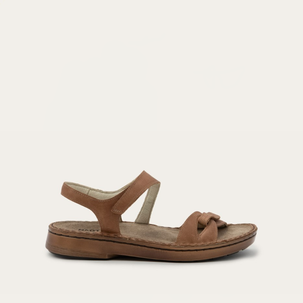 A brown flat backstrap sandal with secure hook and loop closures and a polyurethane sole, designed for comfort and all-day wearability.
