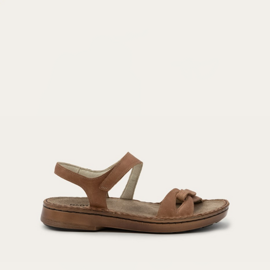 A brown flat backstrap sandal with secure hook and loop closures and a polyurethane sole, designed for comfort and all-day wearability.