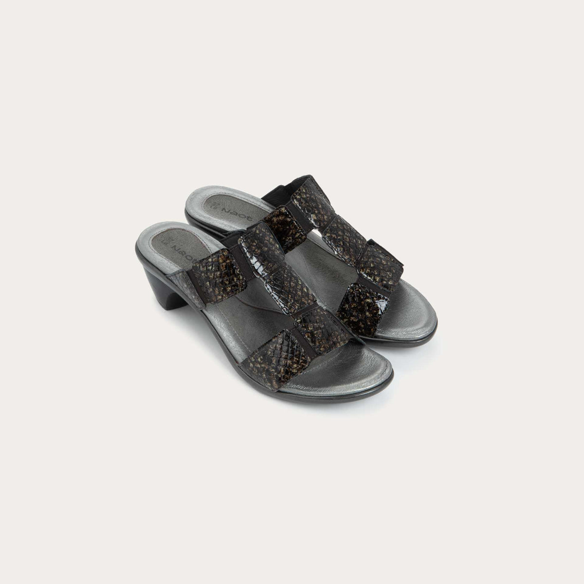 A pair of slip-on t-strap reptile printed sandals with a mid-height heel .