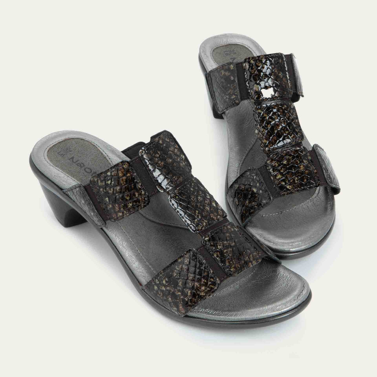 A pair of slip-on t-strap reptile printed sandals with a mid-height heel .