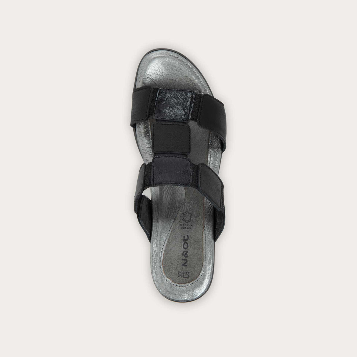 Top view of a slip-on t-strap black sandal with a mid-height heel .