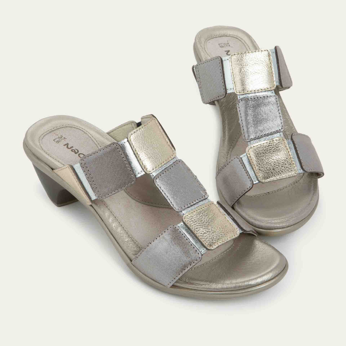 A pair of slip-on t-strap black sandals with a mid-height heel .