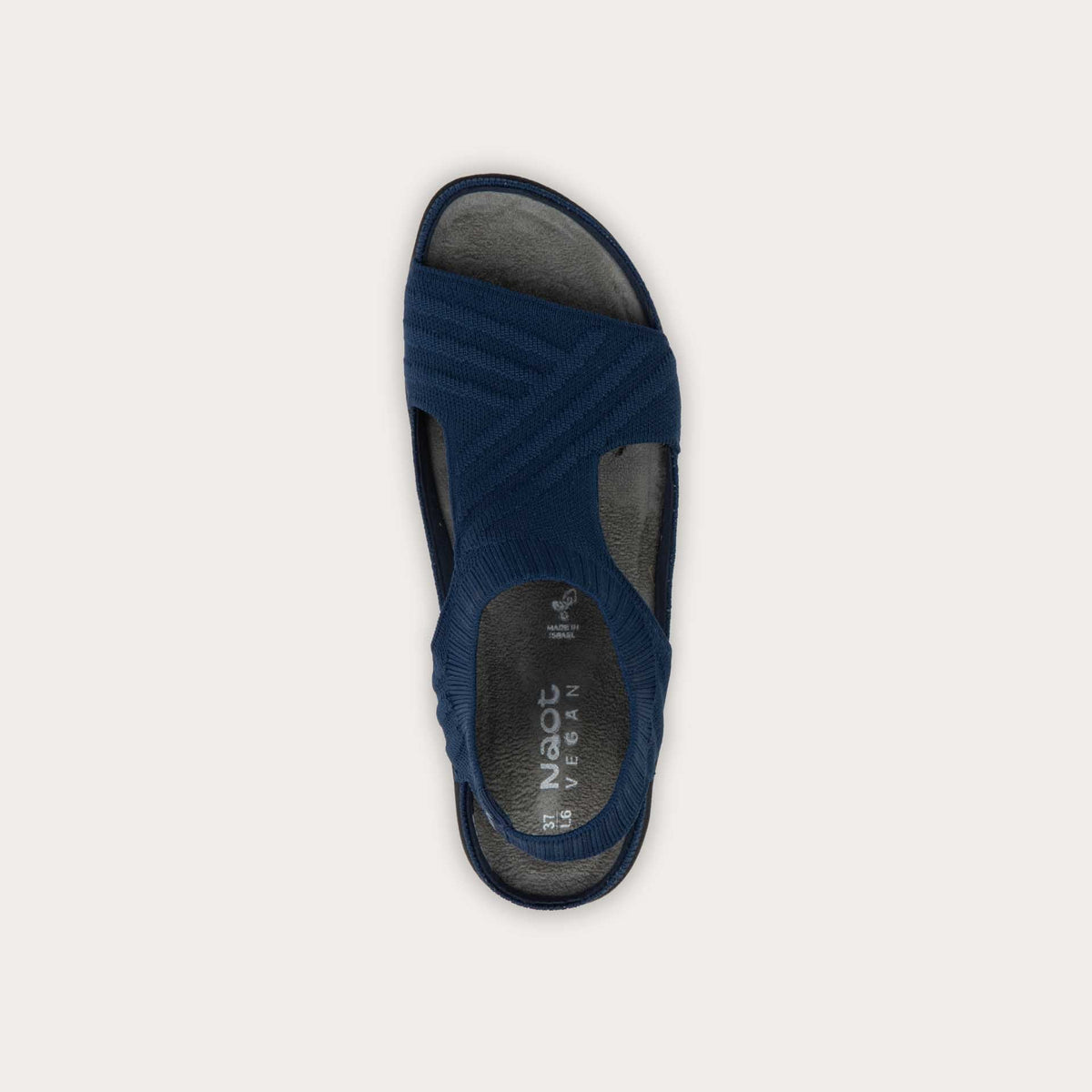 Top view of a navy knit cutout sandal with open toes, elastic ankle strap, and black textured sole.