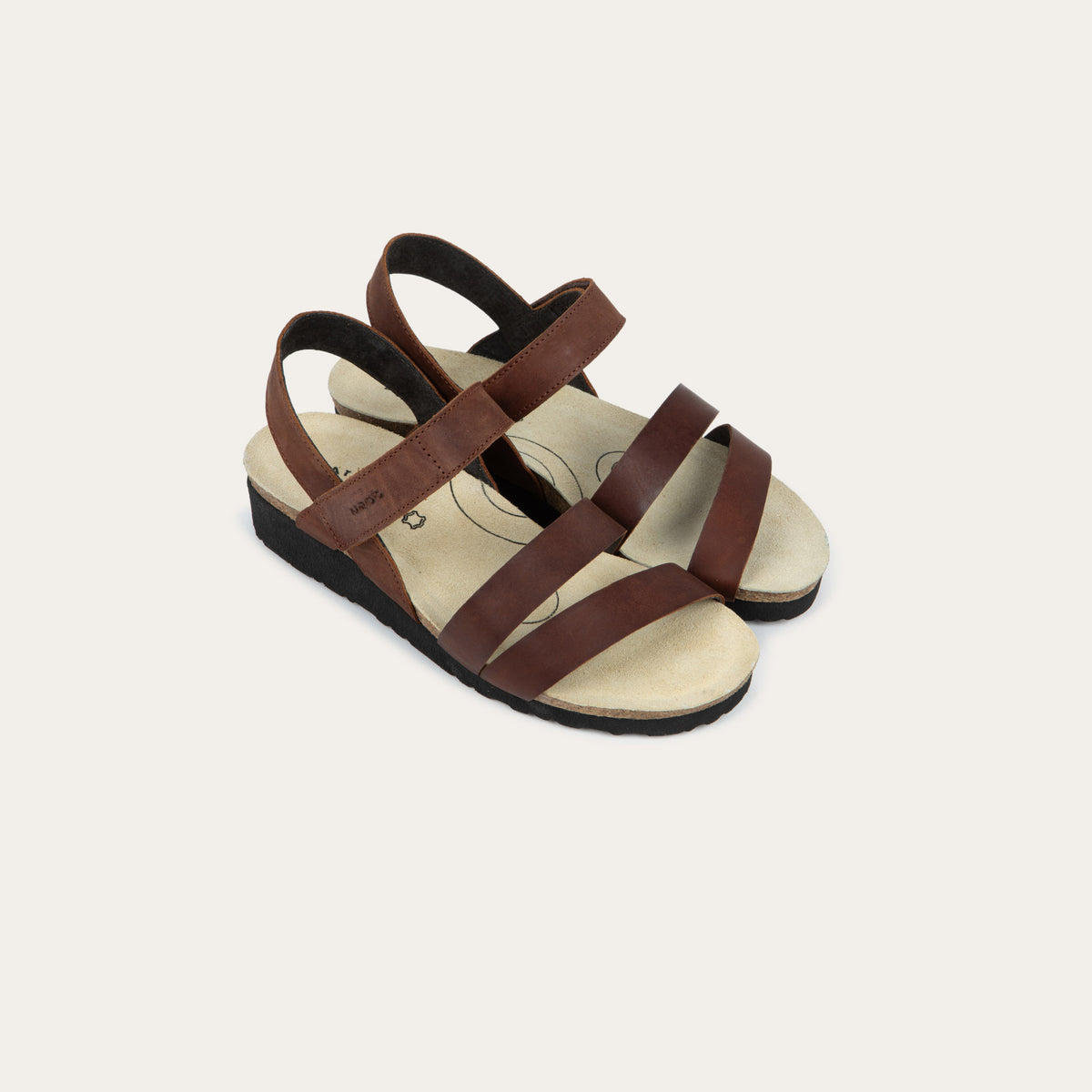 A pair of brown leather sandals with two toe straps, an adjustable ankle strap, and a cork platform sole.