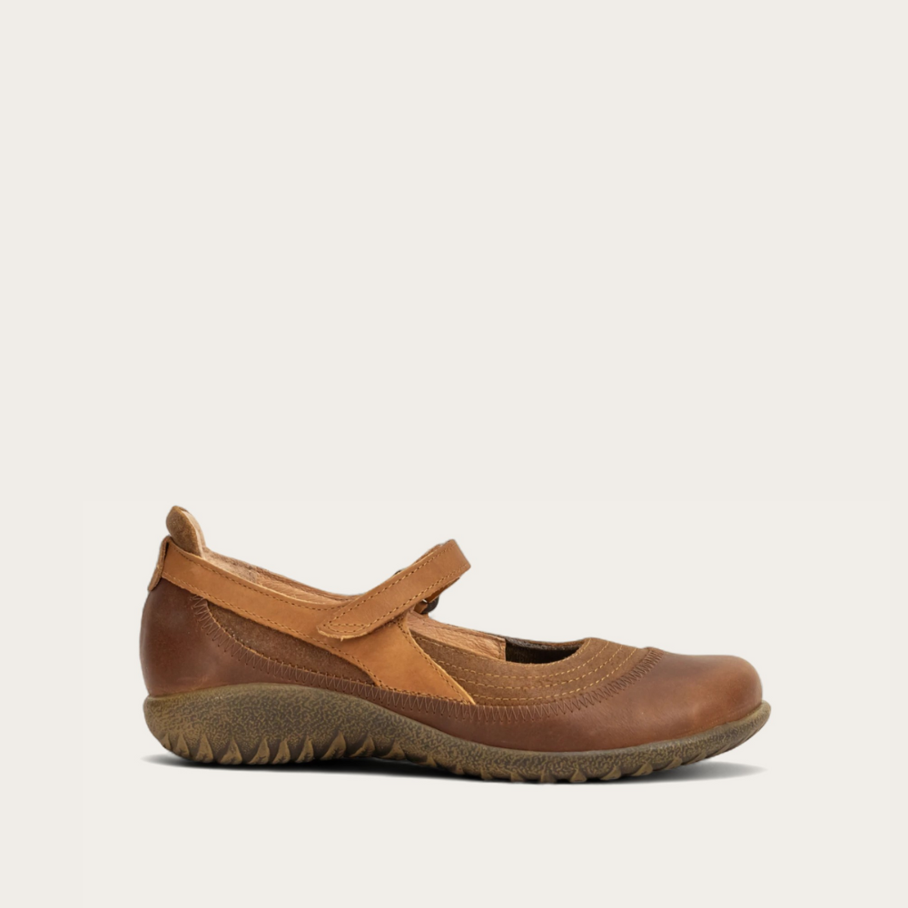 Profile view of a brown leather Mary Jane shoe with a hook-and-loop strap