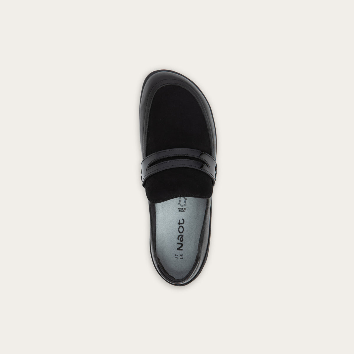 Top view of a black slip-on loafer featuring a mix of matte leather and soft suede textures with a glossy patent leather strap across the vamp.