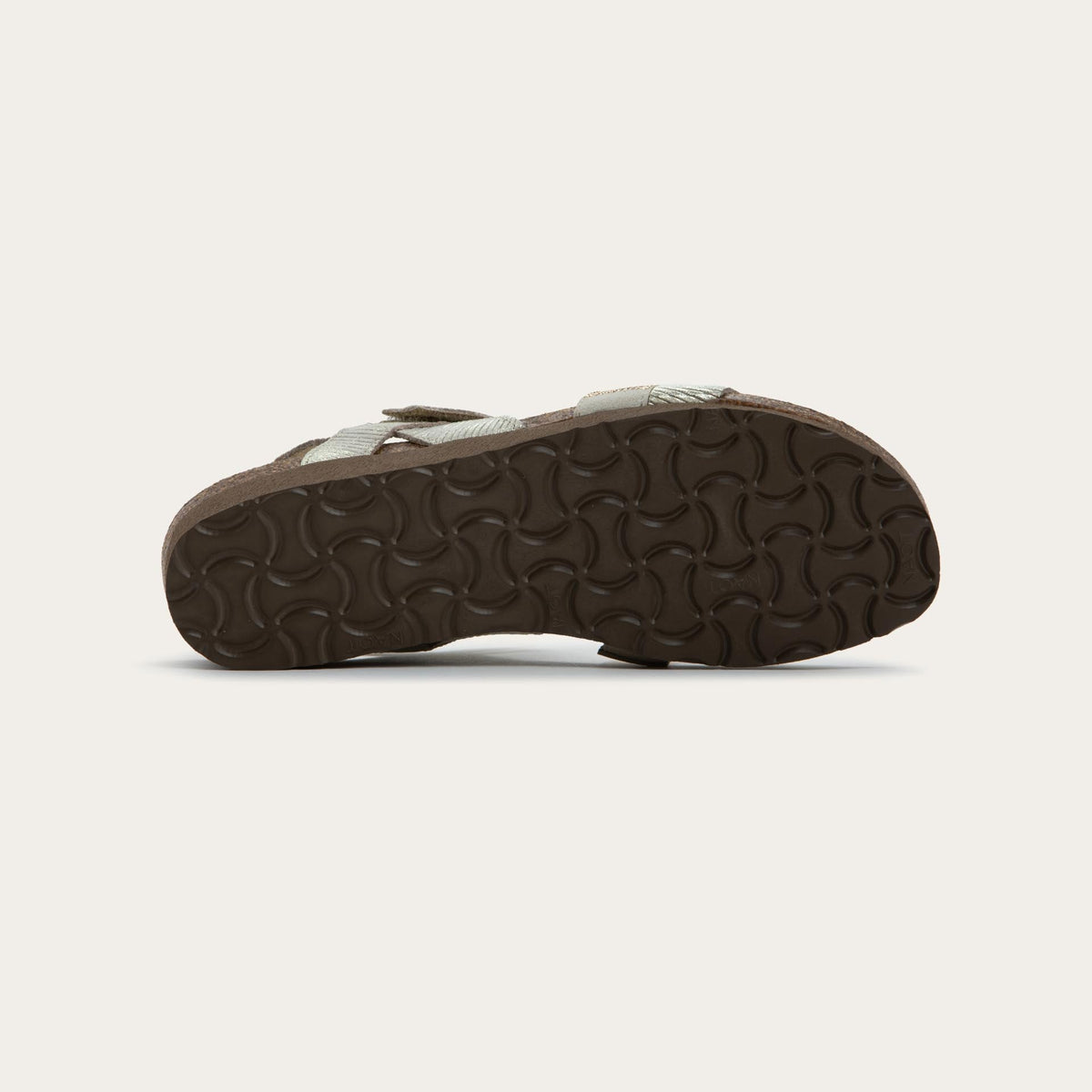Bottom view of a beige sandal with two textured straps and a studded strap on a cork and black rubber sole,