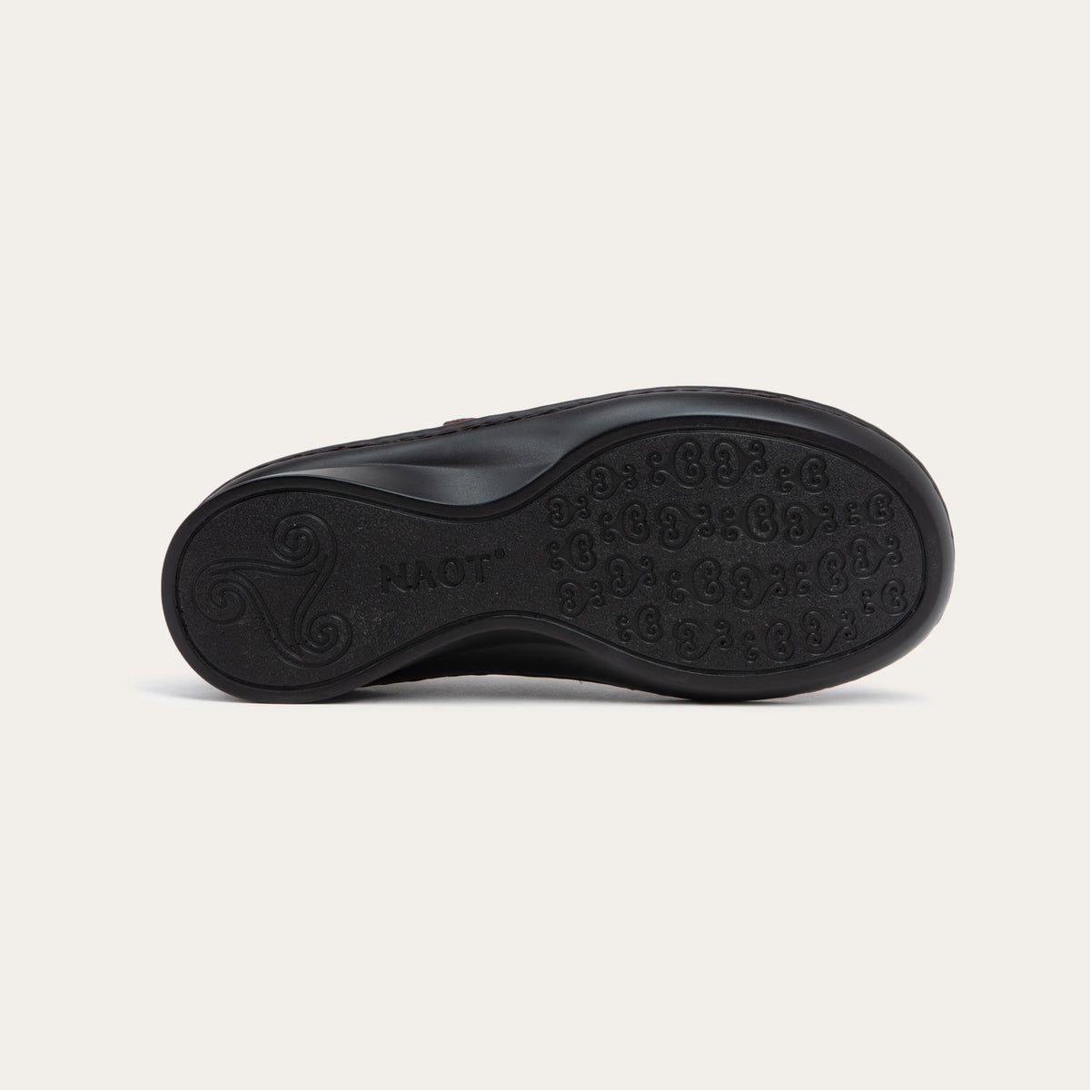 Bottom view of a red maryjane on a black sole featuring a simple buckle and small cutout detail on the side