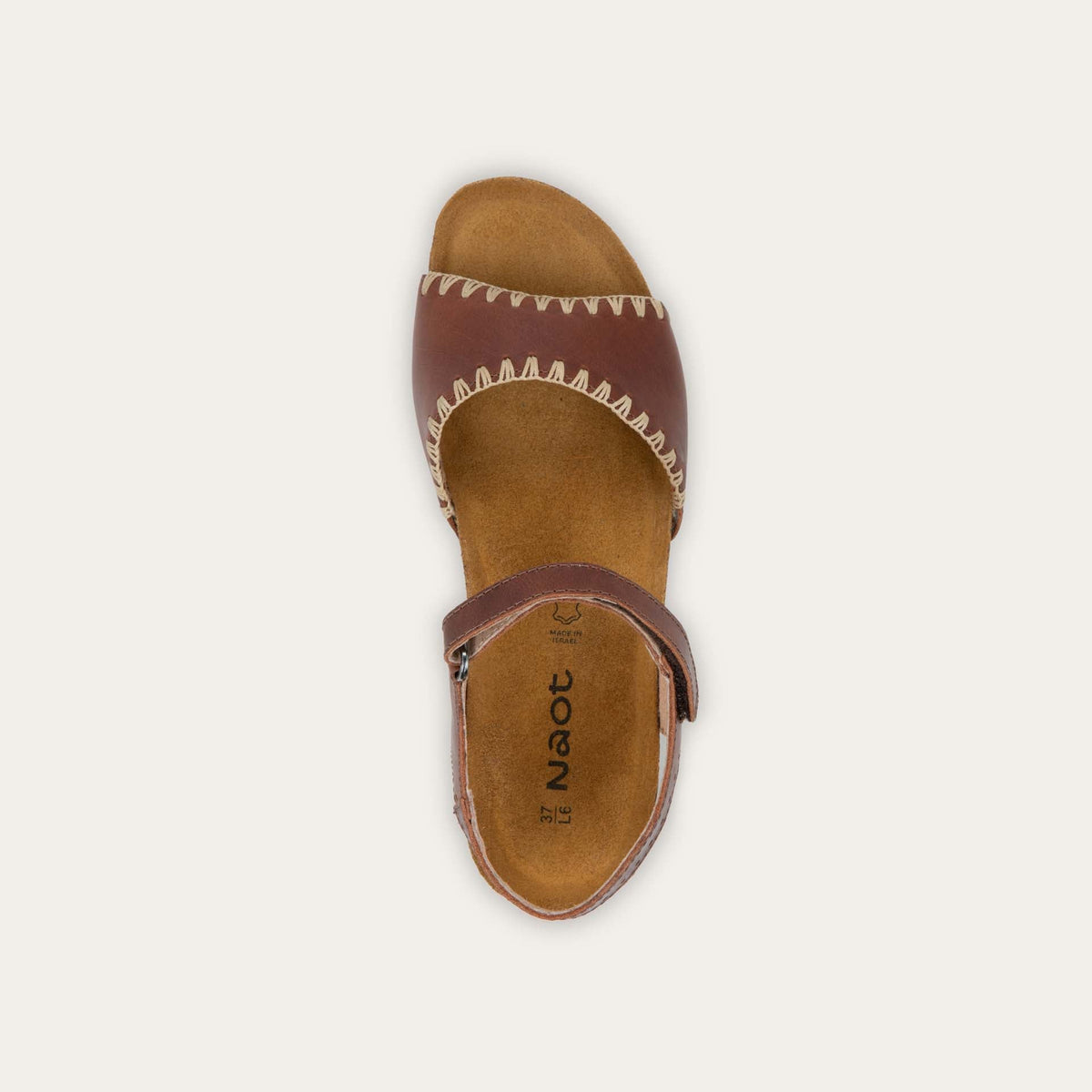 Top view of a brown sandal featuring a toe strap with contrast stitiching, adjustable ankle strap, and a cork footbed.