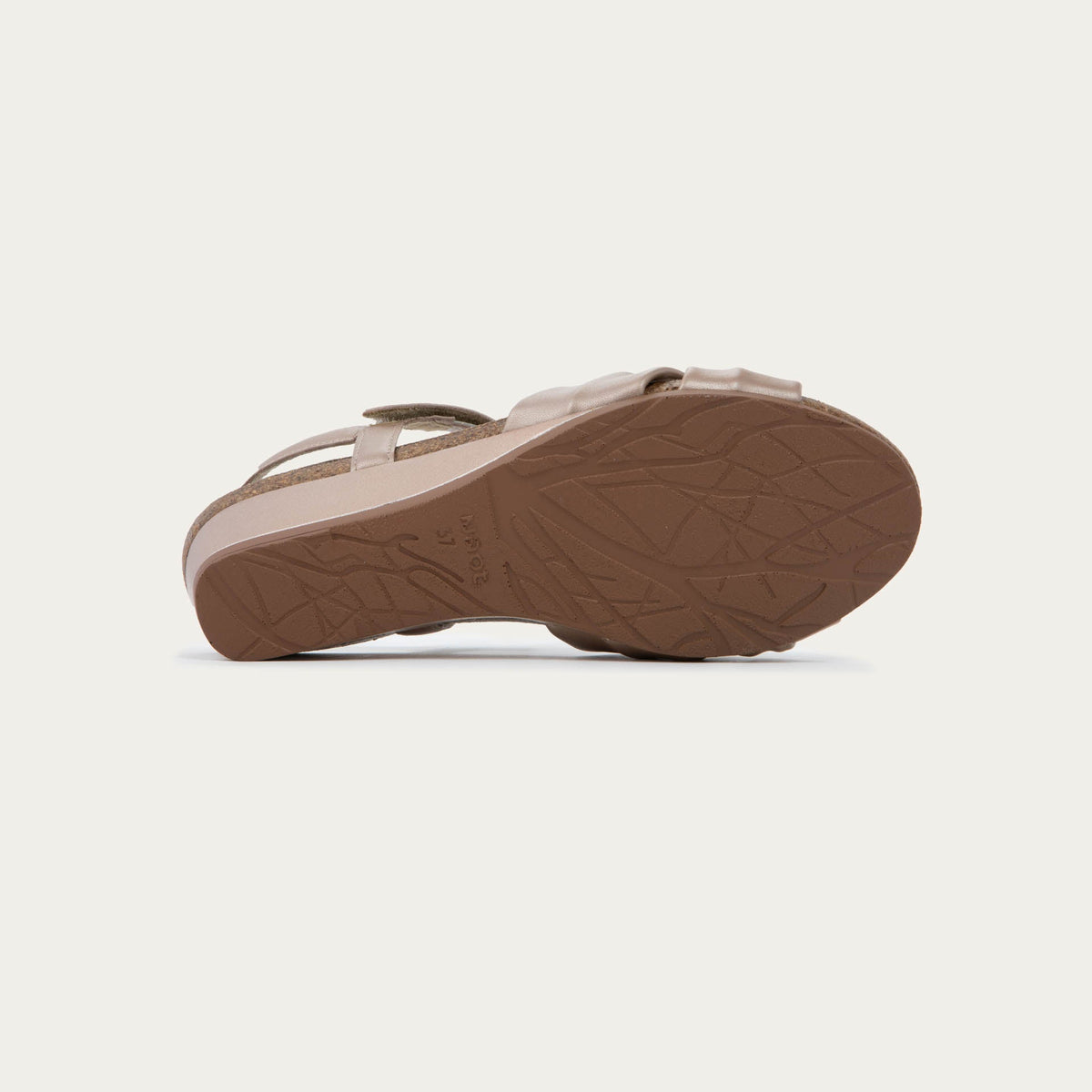 Bottom view of a mauve wedge sandal with an ankle strap and twisted front strap, featuring a cork footbed and wedge heel. 