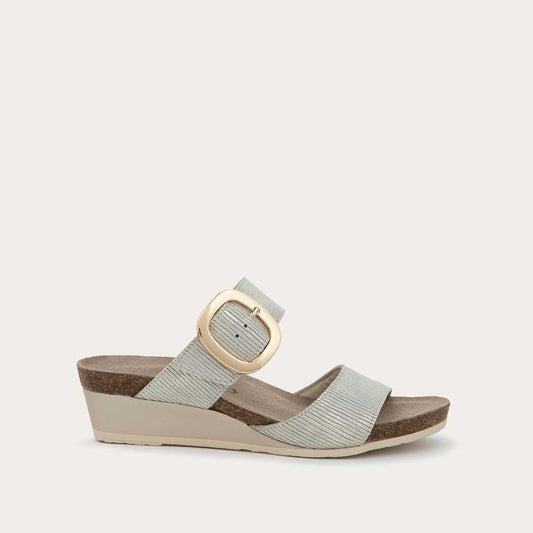 Profile view of a metallic gray textured wedge sandal with two straps and a large gold buckle. 