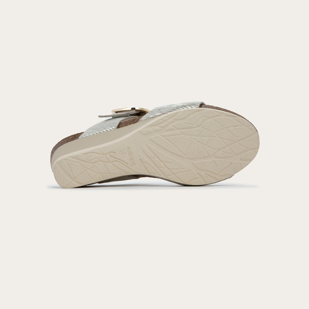 Bottom view of a metallic gray textured wedge sandal with two straps and a large gold buckle. 