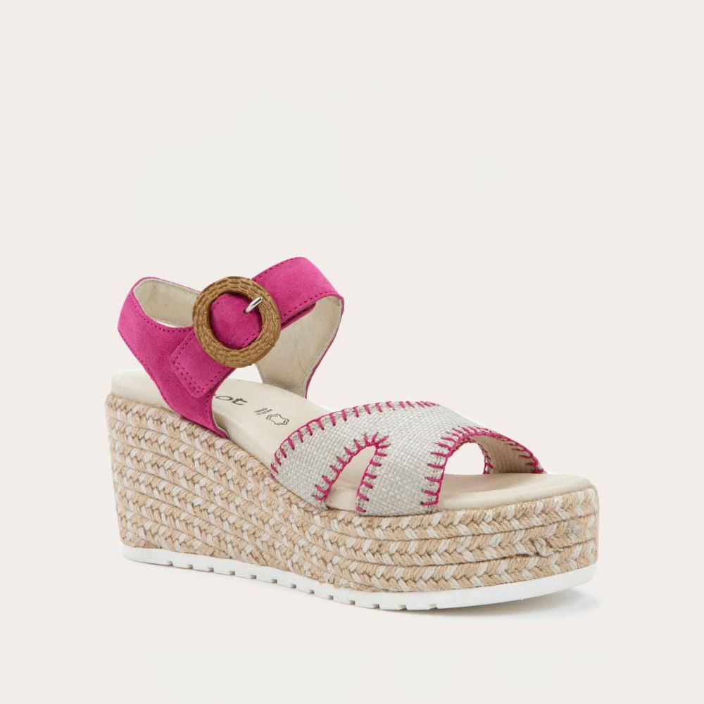 Angled profile view of a beige/pink wedge sandal with a woven platform and pink suede ankle strap, fastened by a circular buckle. 