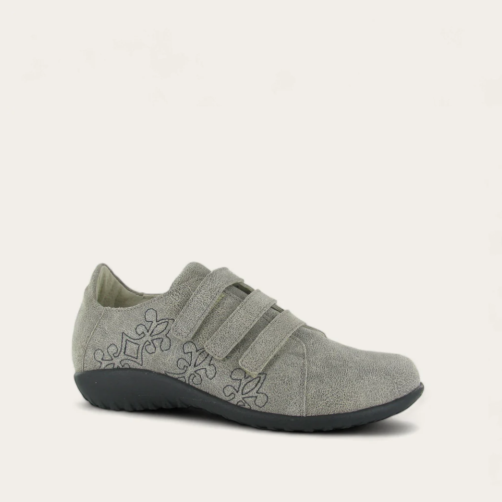 A gray Mihi sneaker with three velcro straps and a floral pattern on the side, featuring a low heel and a round toe.