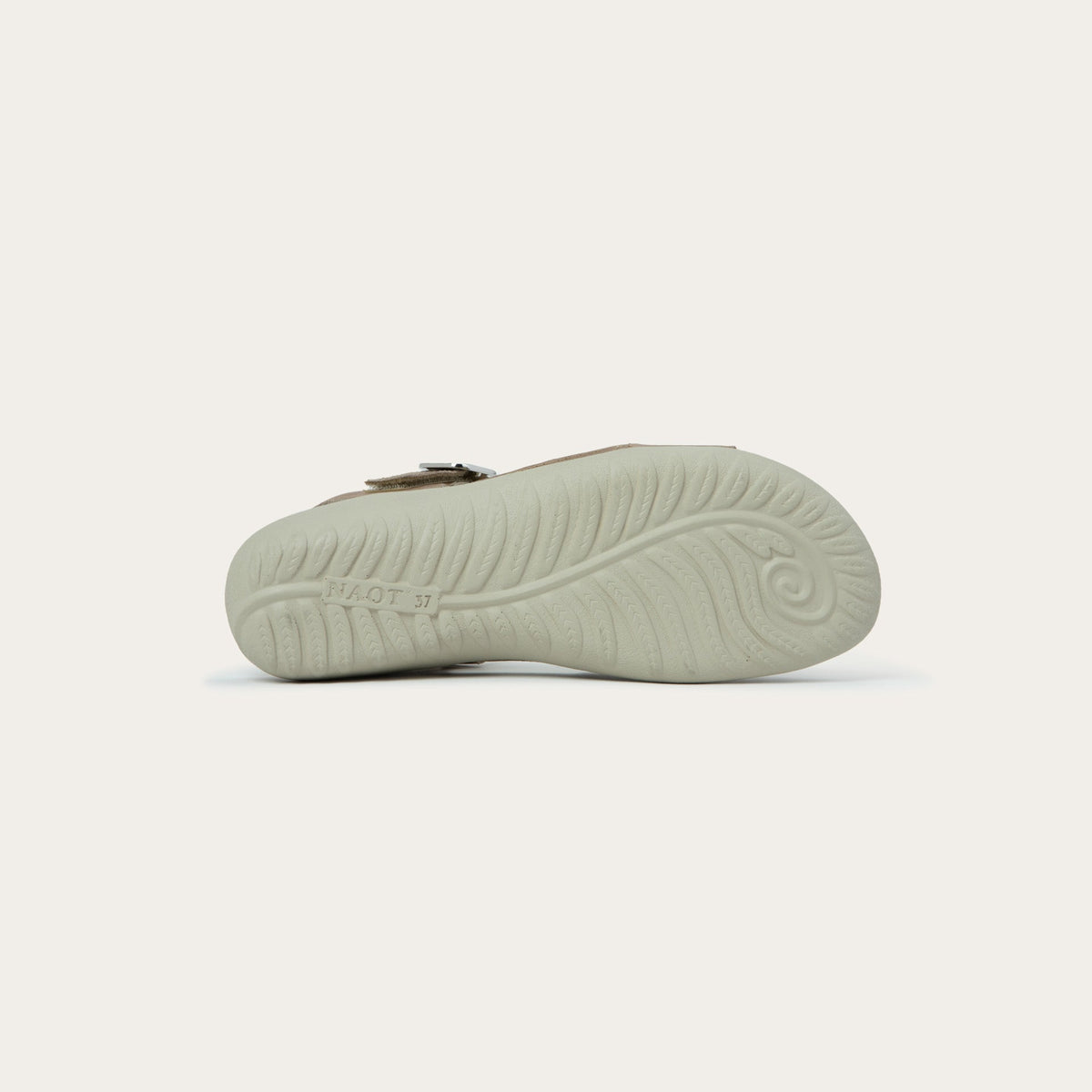 Bottom view of a beige, open toe sandal, featuring a toe strap and asjustable ankle strap with a silver accent buckle.