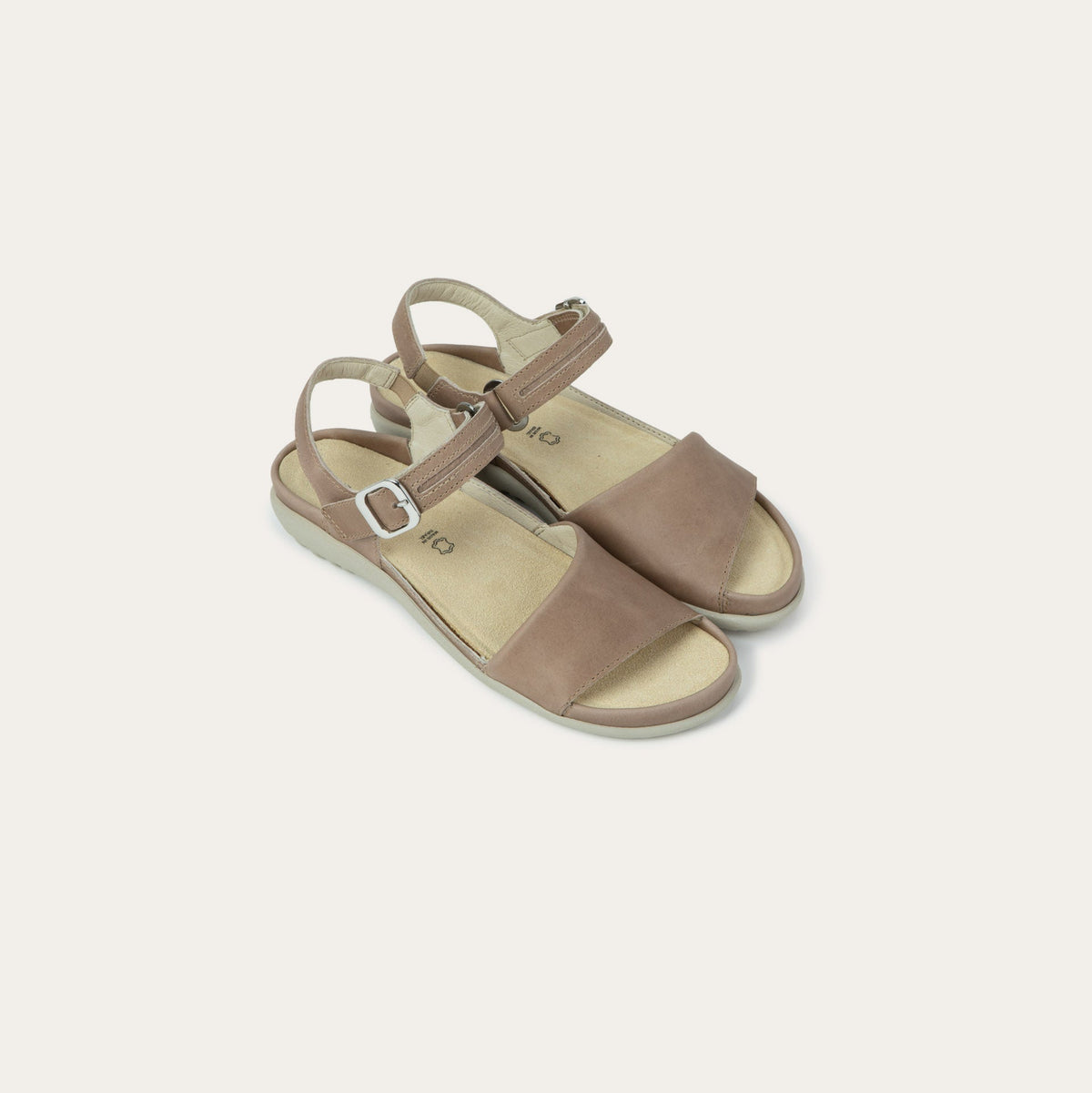 Pair of  beige, open toe sandals, featuring a toe strap and asjustable ankle strap with a silver accent buckle.