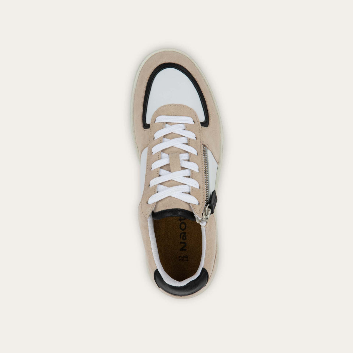 Top view of a multicolored white, beige, and black sneaker with laces and a side zipper.