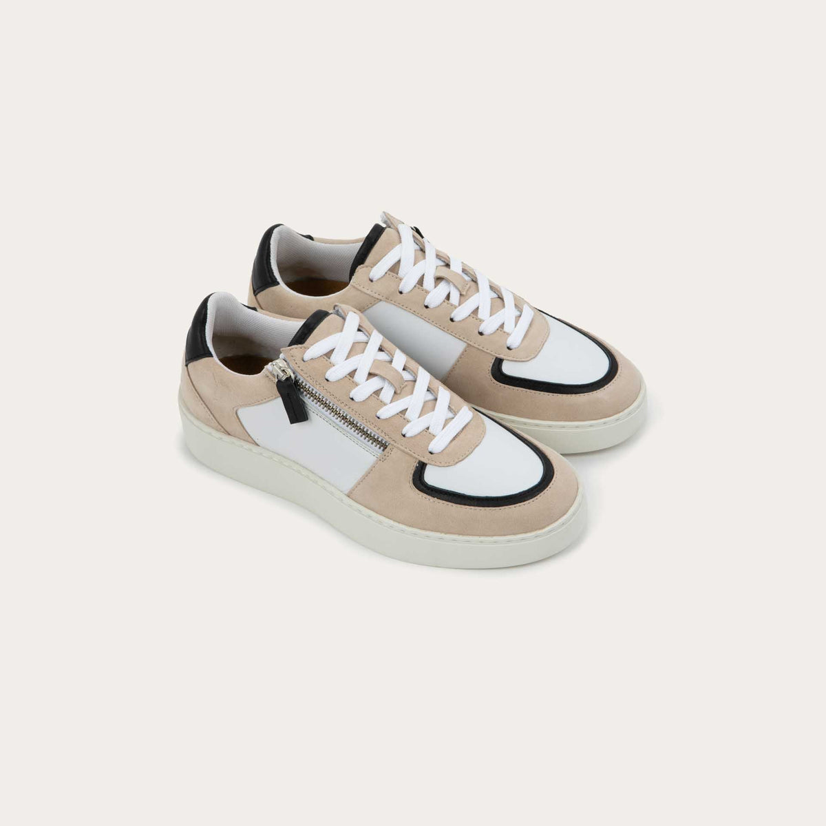 Pair of multicolored white, beige, and black sneakers with laces and a side zipper.