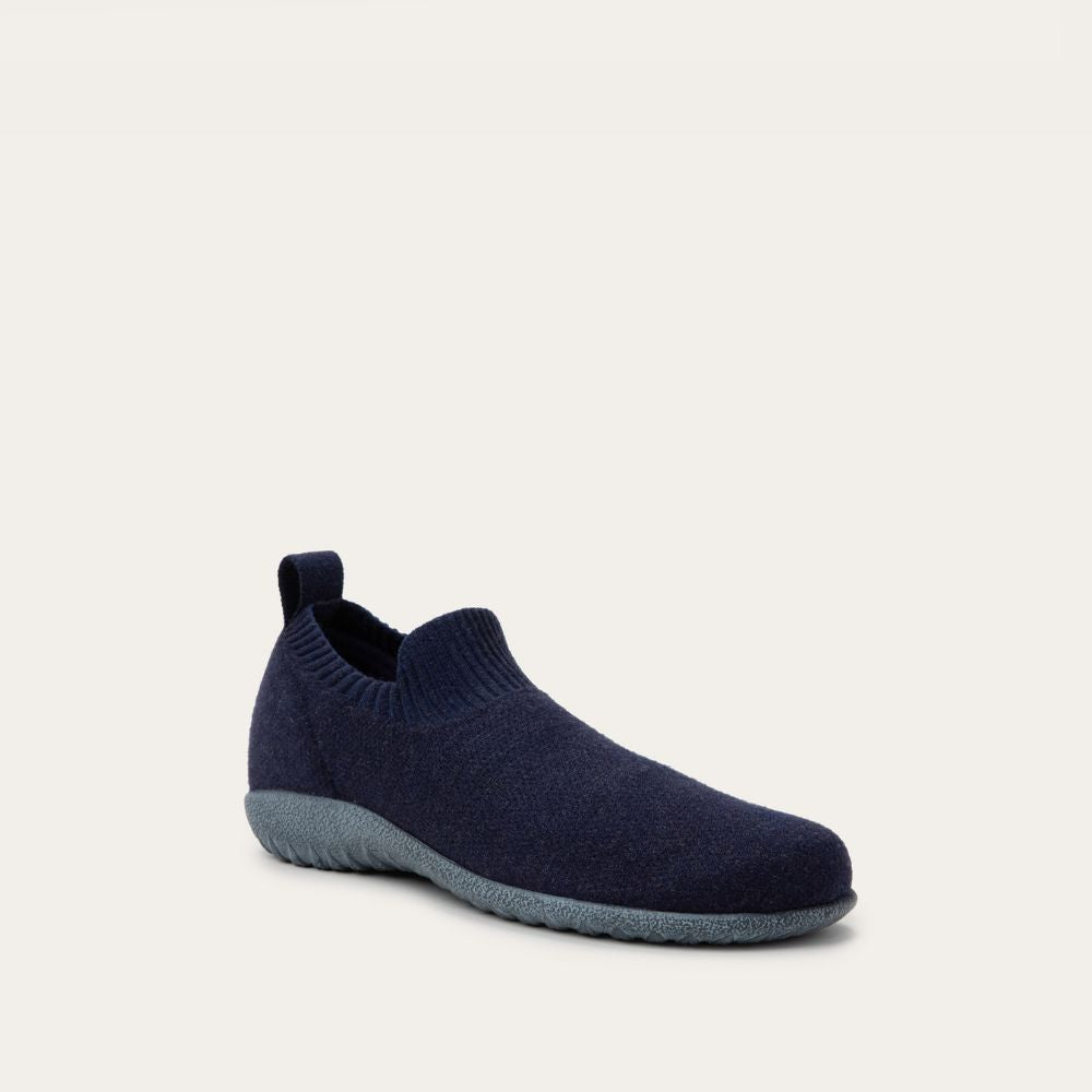 Angled profile view of a navy knit slip-on vegan shoe