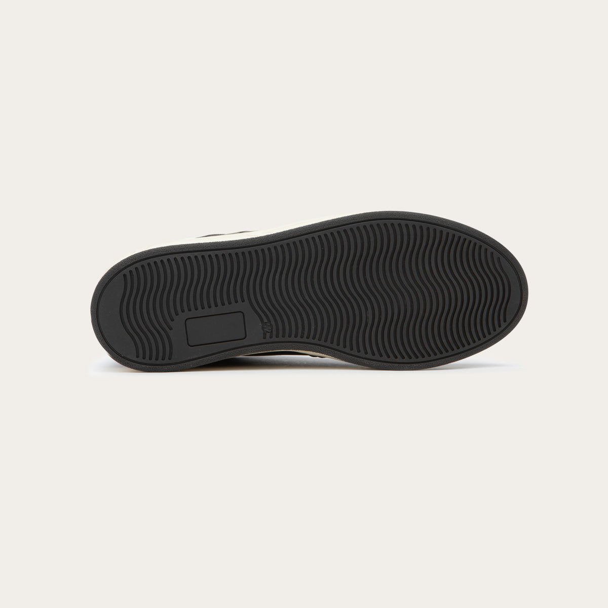 Bottom view of a gray sneaker with brown accents on a white sole.