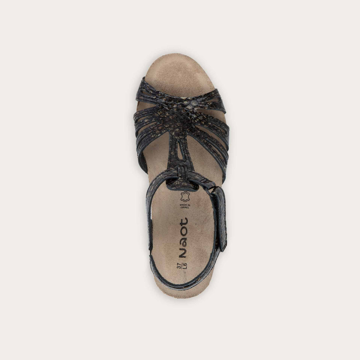 Top view of a  reptile printed wedge sandal with strappy design, open toe, and adjustable ankle strap on a cork footbed.