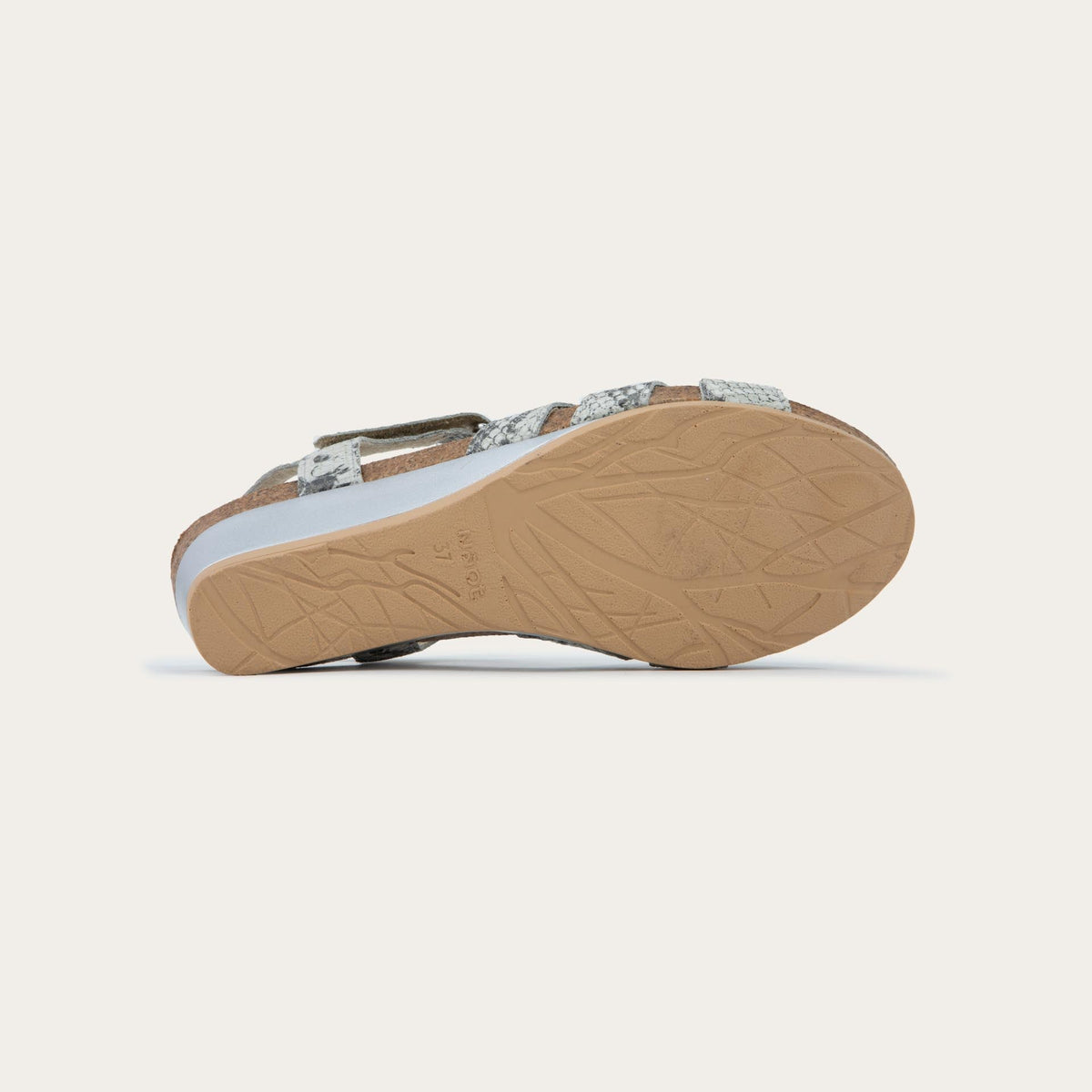 Bottom view of a  black wedge sandal with strappy design, open toe, and adjustable ankle strap on a cork footbed.